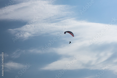 silhouette of paraglider on blue sky