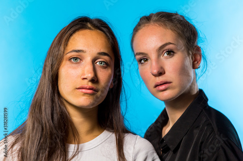 Tableau sur toile Portrait of Two Young Women on Blue Background
