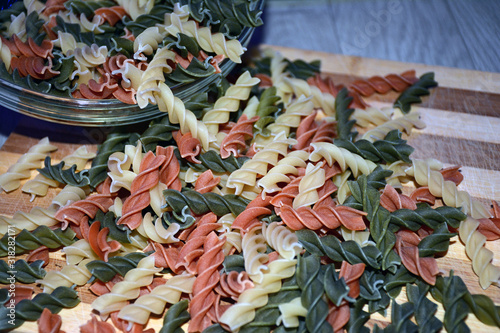 Multi-colored pasta on a wooden board. Food.