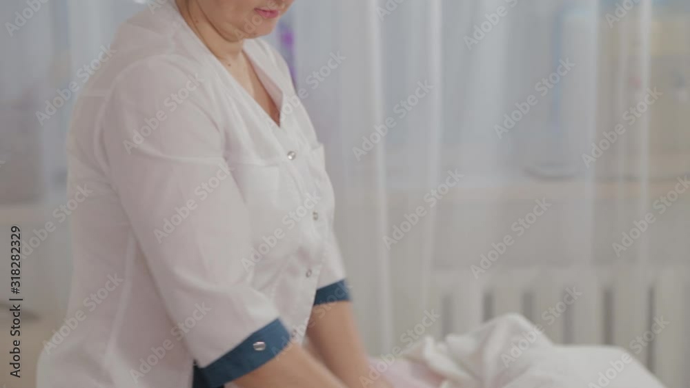 Female massage therapist doing massage over the entire length of the legs of a young girl. Female massage therapist doing massage over the entire length of the legs of a young girl.