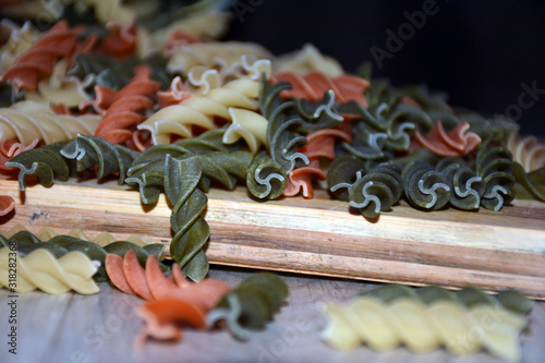 Multi-colored pasta on a wooden board. Food.