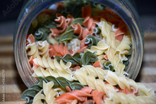Multi-colored pasta on a wooden board. Food.
