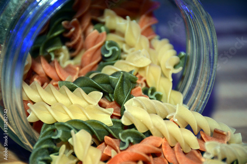 Multi-colored pasta on a wooden board. Food.