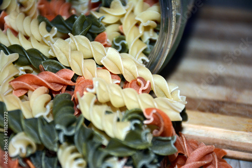 Multi-colored pasta on a wooden board. Food.