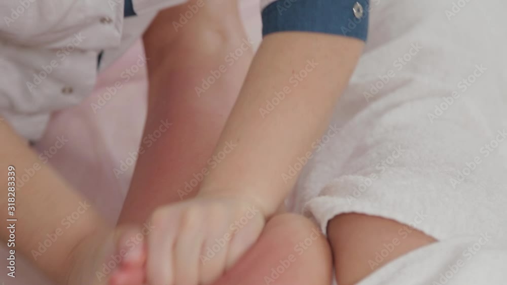 Female massage therapist doing massage over the entire length of the legs of a young girl. Female massage therapist doing massage over the entire length of the legs of a young girl.