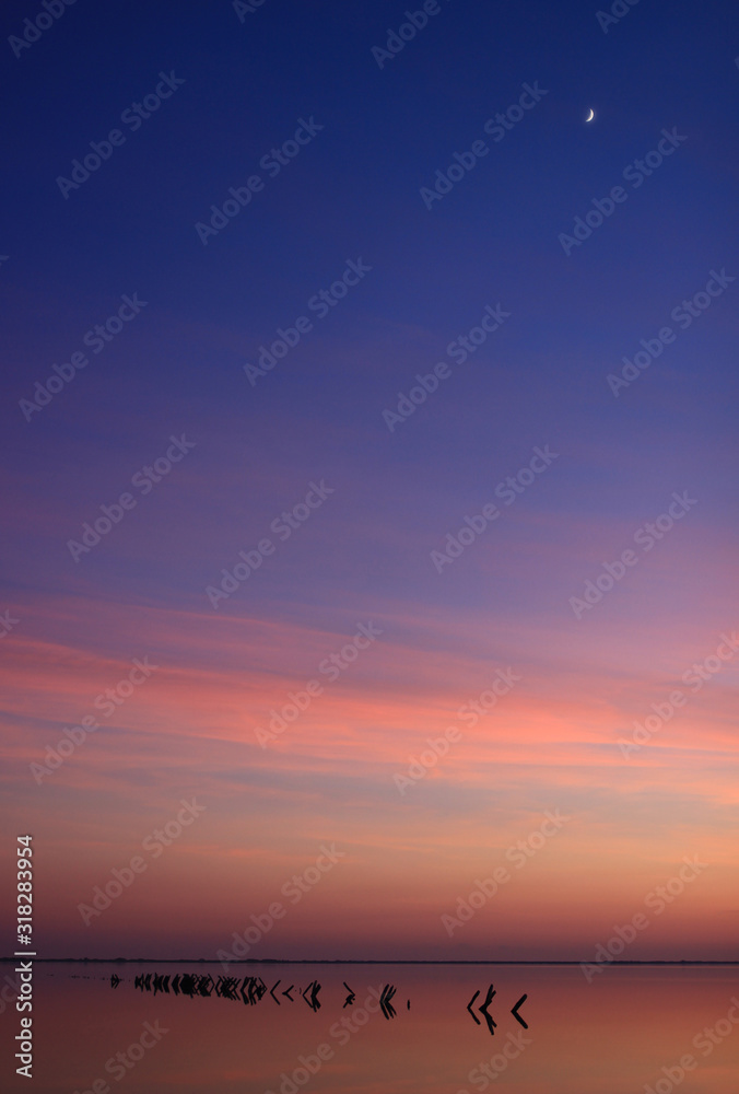 Fototapeta premium Croissant de lune et crépuscule du 31 décembre sur les étangs des Salines de Villeneuve-lès-Maguelone (Hérault - France)