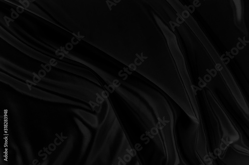 Black gray satin dark fabric texture luxurious shiny that is abstract silk cloth background with patterns soft waves blur beautiful.