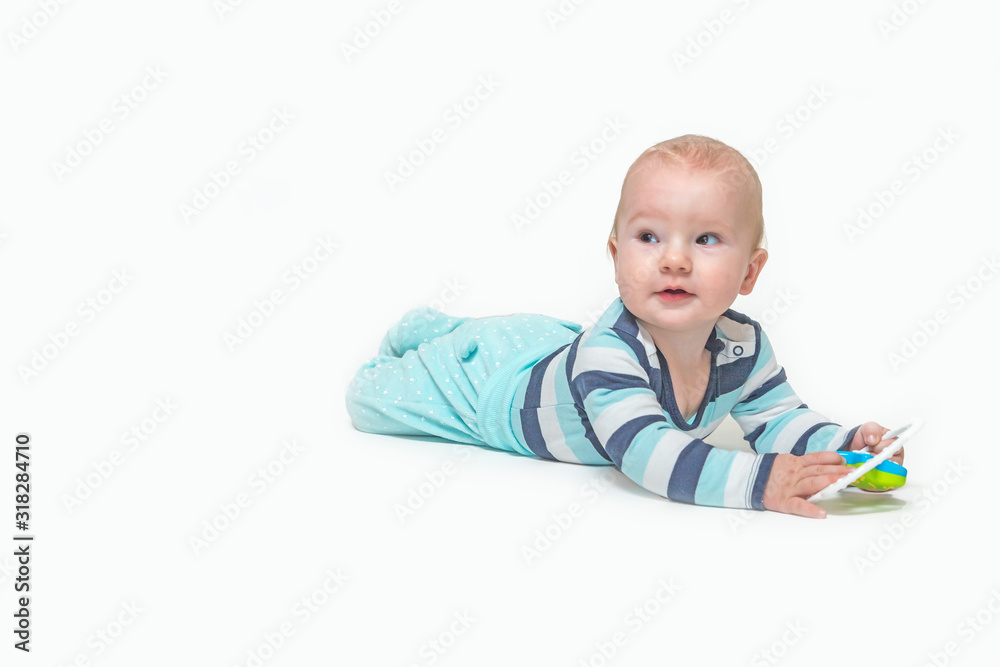 Cute baby boy is lying on white background holding a toy. Photo contains a lot of free space for your use. All potential trademarks are removed. Cute baby boy is lying on white background holding a toy. Photo contains a lot of free space for your use. All potential trademarks are removed.