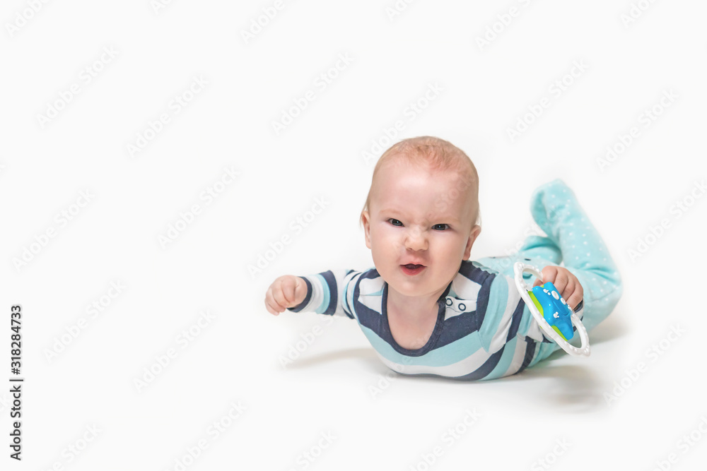 Grinning baby boy is lying on white background holding a toy. Photo contains a lot of free space for your use. All potential trademarks are removed. Grinning baby boy is lying on white background holding a toy. Photo contains a lot of free space for your use. All potential trademarks are removed.