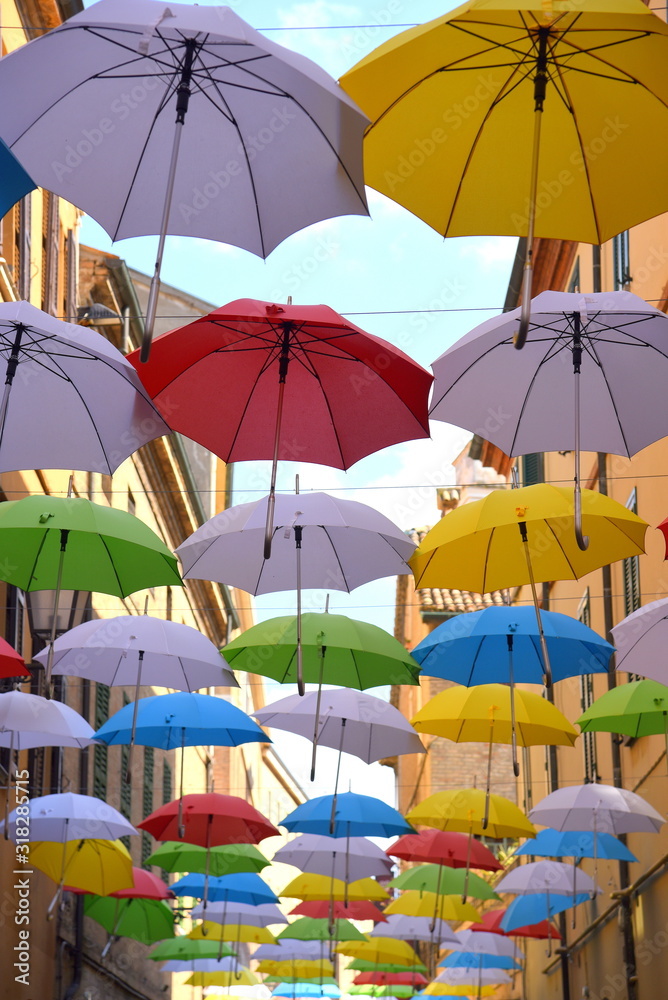 Bunte Regenschirme in Reihen über einer Straße aufgespannt