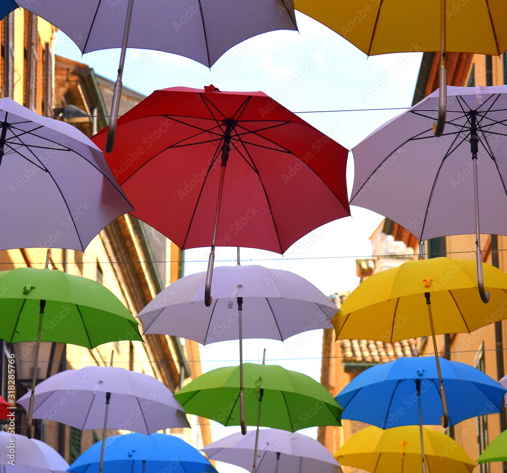 Über einer Straße aufgespannte, bunte Regenschirme 