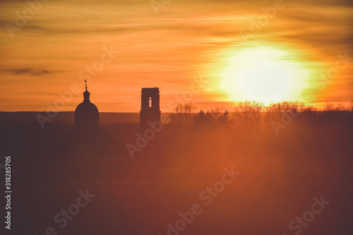 silhouette of church on a sunset background  an abandoned church in field at sunset  church on colorful sunset sky