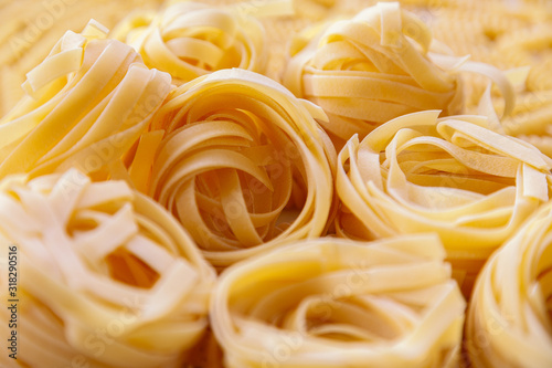 Italian homemade rolled raw fettuccine pasta background. Angle view