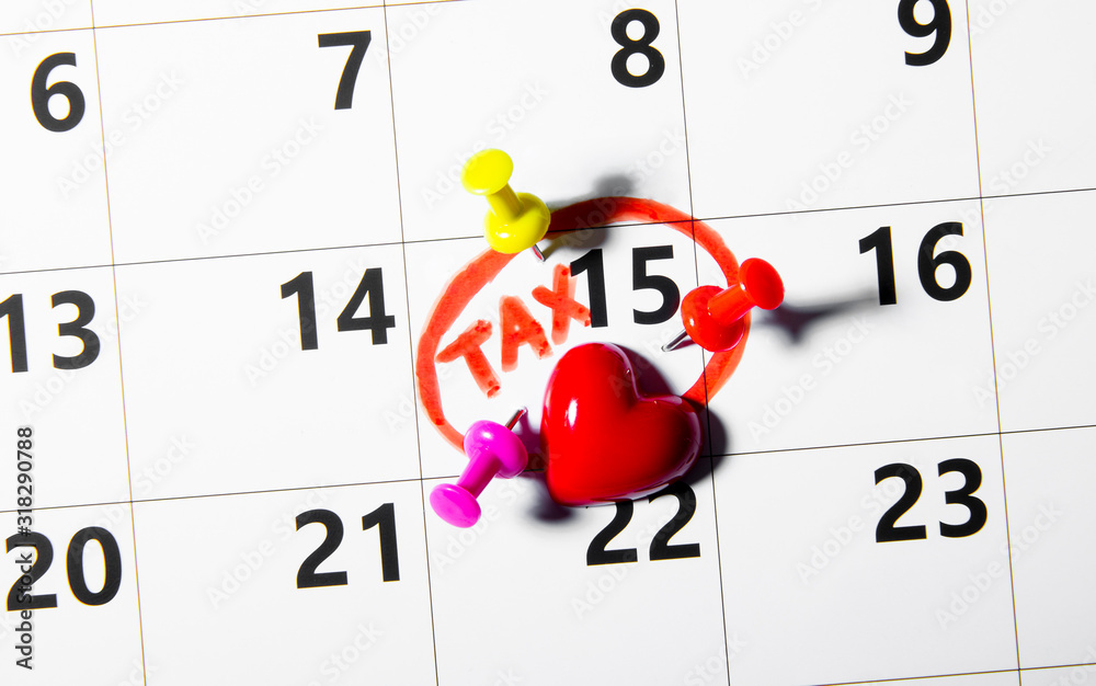 Tax Day 15 April 2020 concept. Reminder calendar with colorful pins and red markings text.