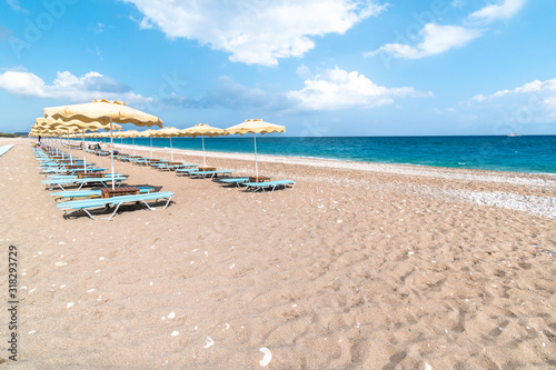 Empty sunbeds and umbrella on Afandou beach near Faliraki  Rhodes  Greece 