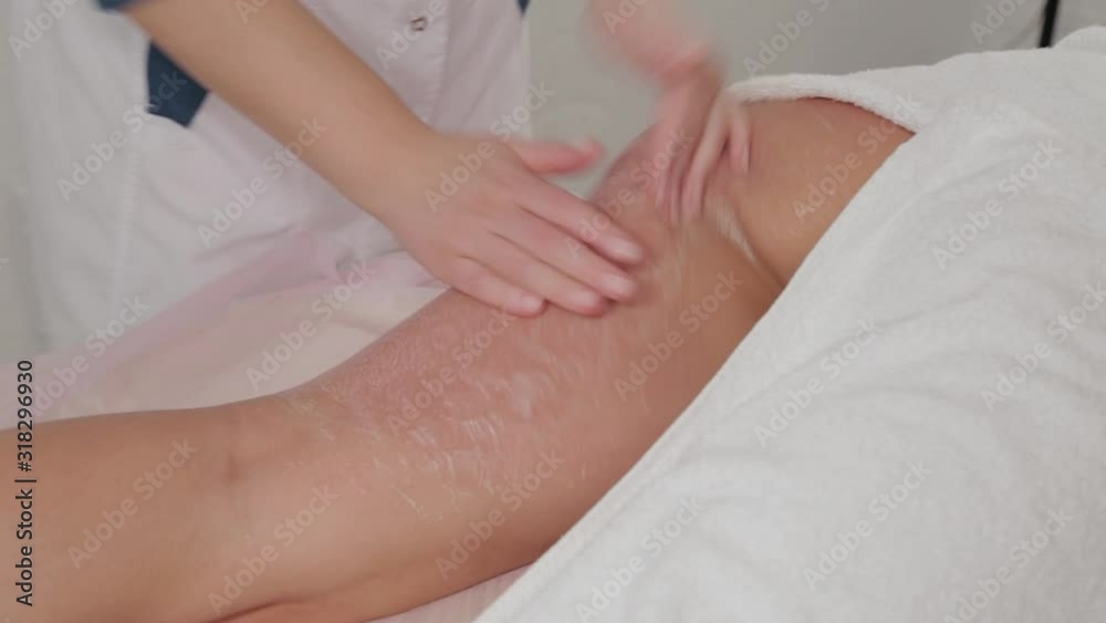 Woman massage therapist makes honey massage to a young girl in a massage parlor. Woman massage therapist makes honey massage to a young girl in a massage parlor.