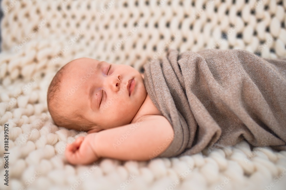 Adorable baby lying down on the sofa over blanket at home. Newborn relaxing and sleeping comfortable Adorable baby lying down on the sofa over blanket at home. Newborn relaxing and sleeping comfortable