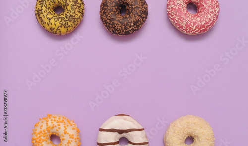 Delicious donuts on violet color background.