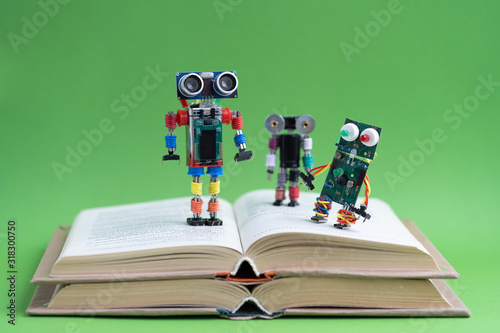 Hand made robot working on the arduino platform with books. Green background. Free space for text. STEM education for children and teenagers, robotics and electronics. DIY. AI. STEAM. Concept.