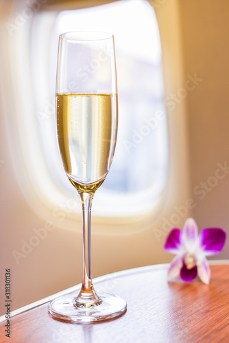 фотографія A glass of wine placed on the table in the passenger cabin on the plane