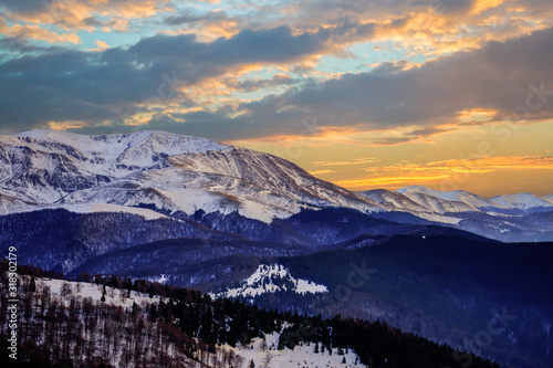 Sunset or sunrise panoramic view on stunning mountains. Winter scene with sunset in mountains.