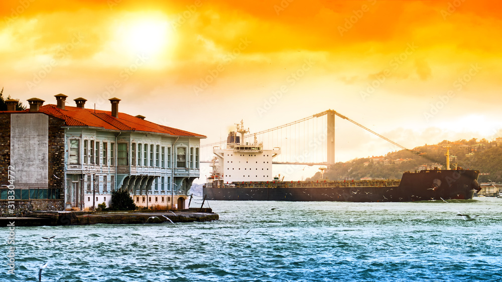 scenic istanbul city turkey landmark with sea cargo ship sailing along bosphorus strait against orange sky background. Wide panorama view of turkish historic urban town landscape at winter time