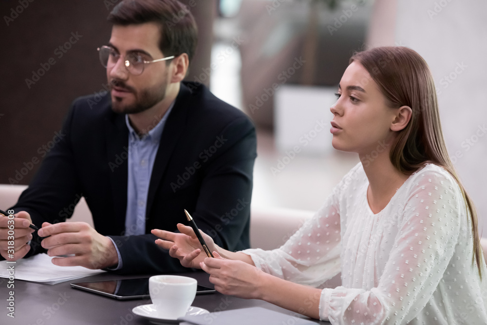 Concentrated young business people involved in negotiations at office.