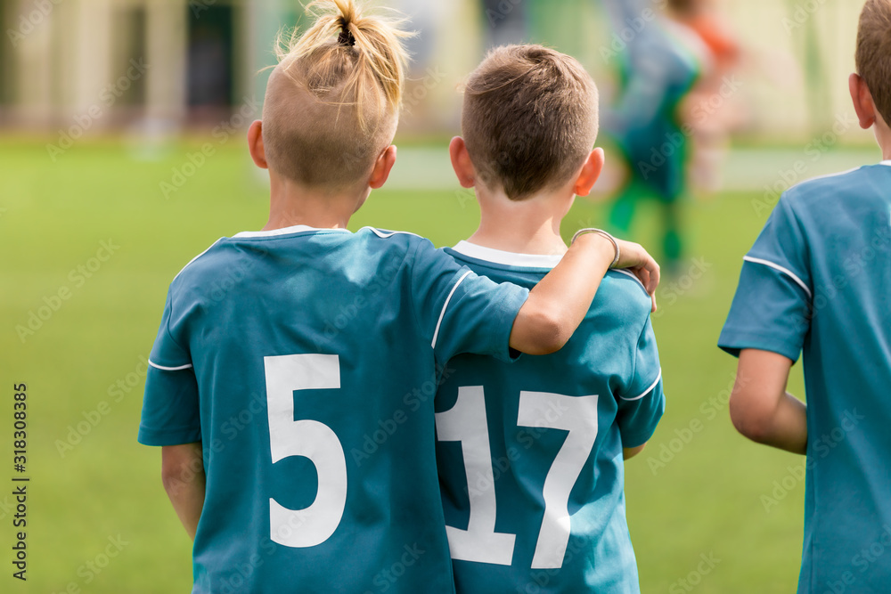Fototapeta premium Two young boys as a teammates in sports team. Friendship in junior sport. Young soccer players hanging out together