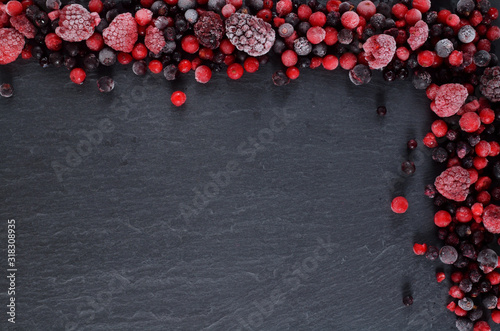 Billede på lærred Frozen berries fruits in the upper right cornern on slate slab