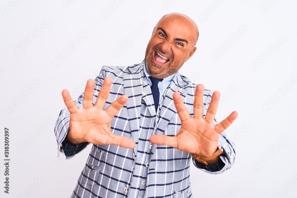 Middle age businessman wearing suit standing over isolated white background afraid and terrified with fear expression stop gesture with hands, shouting in shock. Panic concept. Middle age businessman wearing suit standing over isolated white background afraid and terrified with fear expression stop gesture with hands, shouting in shock. Panic concept.