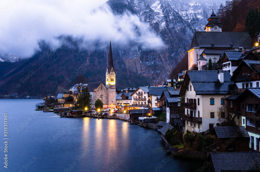 Classic view of Hallstatt, Austria, with the mountains in background at dusk in early winter