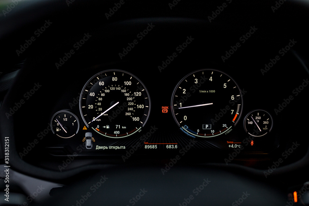 Instrument panel with tachometer and speedometer. Close up image of illuminated car dashboard.