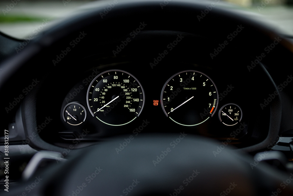 Instrument panel with tachometer and speedometer. Close up image of illuminated car dashboard
