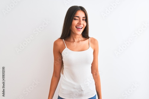 Young beautiful woman wearing casual t-shirt standing over isolated white background winking looking at the camera with sexy expression, cheerful and happy face.
