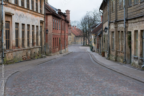 Old city street with old stone and wooden facades and stone paving road