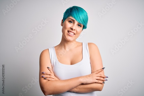 Young beautiful woman with blue fashion hair wearing casual t-shirt over white background happy face smiling with crossed arms looking at the camera. Positive person.