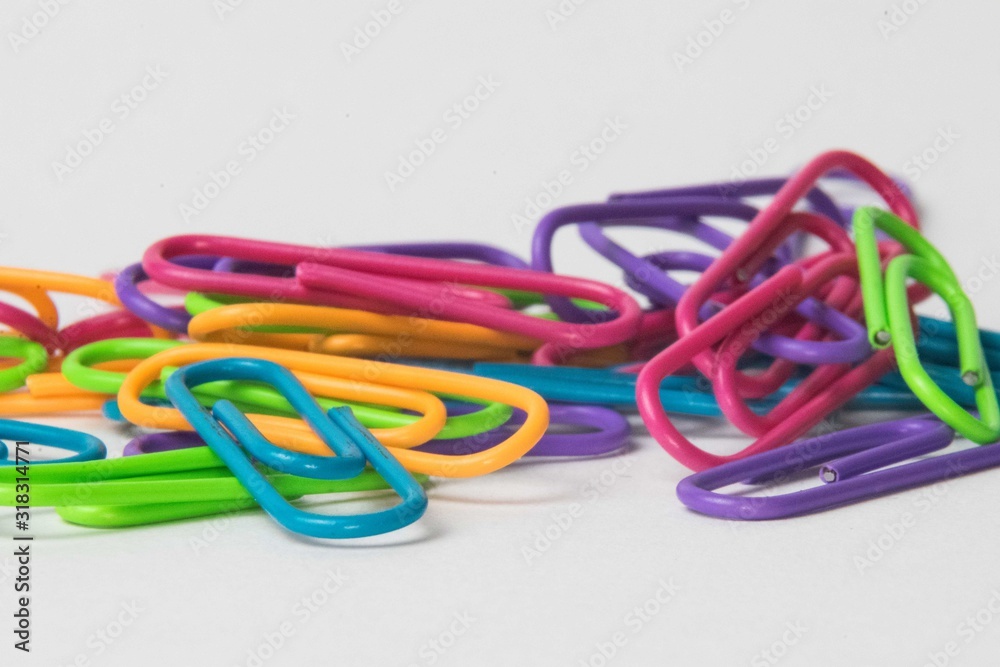 Close-up of multicolored paper clips on a white background Close-up of multicolored paper clips on a white background