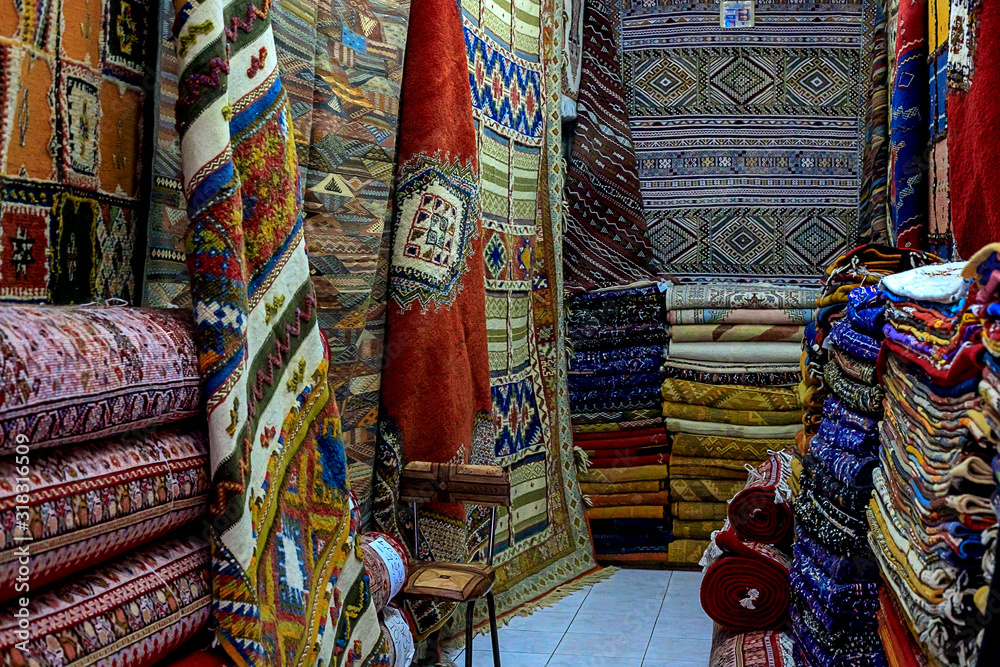 Moroccan carpets with vibrant colors for sale in the narrow street of Rabat in Morocco with selective focus.