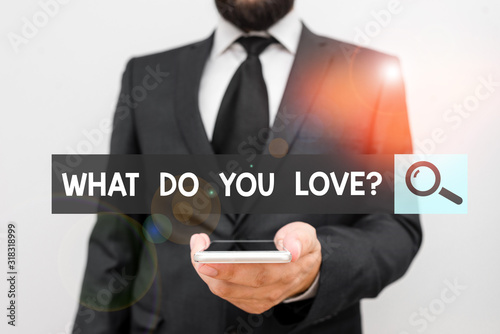 Writing note showing What Do You Love question. Business concept for Enjoyable things passion for something inspiration Male human wear formal work suit hold smartphone using hand
