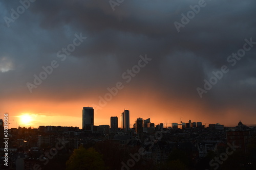 Silhouette of Brussels city at sunset under grey clouds © keremberk