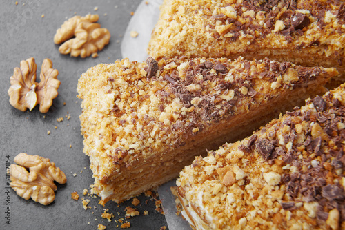 baked pie with cream and nut crumbs, a slice of delicious pastries on a dark background