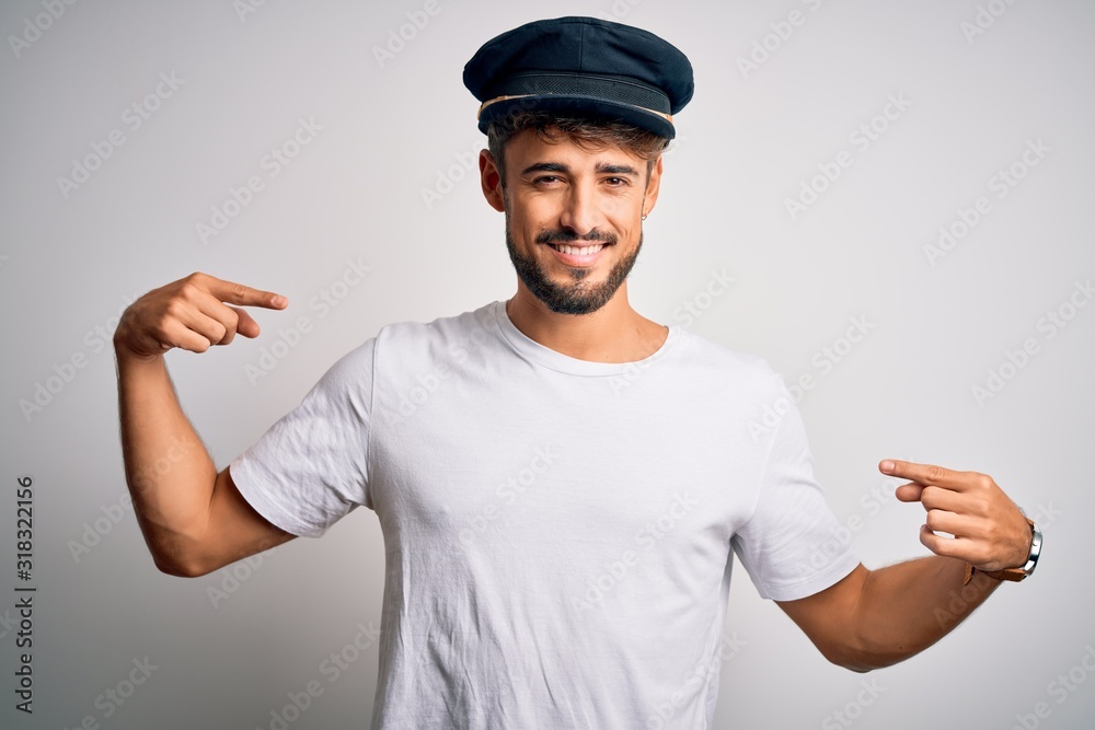 Young driver man with beard wearing hat standing over isolated white background looking confident with smile on face, pointing oneself with fingers proud and happy. Young driver man with beard wearing hat standing over isolated white background looking confident with smile on face, pointing oneself with fingers proud and happy.