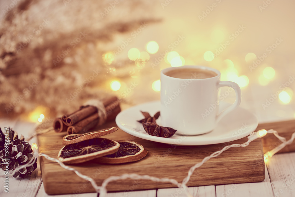 Cup of coffee with a garland lights and decoration on table. Cozy home concept Cup of coffee with a garland lights and decoration on table. Cozy home concept