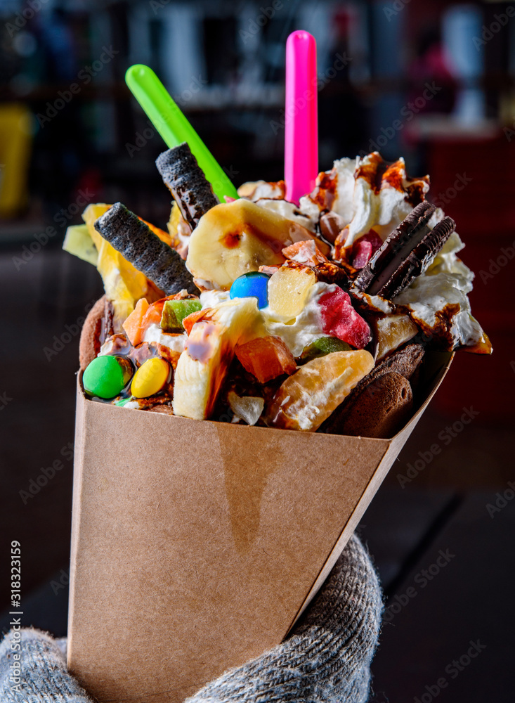 Young woman hands holding Hong Kong bubble waffle with ice cream