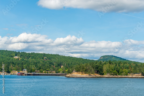 View over inlet, ocean and island with boat and mountains in beautiful British Columbia. Canada. © karamysh