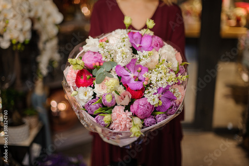 Girl holding a spring bouquet of tender pink  white  red and violet flowers in the wrapping paper