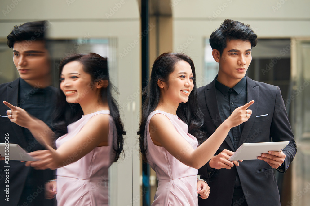 Handsome young man and attractive young woman wearing elegant clothes standing together discussing something