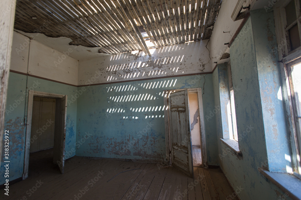 Abandoned and forgotten building and room left by people and being taken over by encroaching sandstorm, Kolmanskop ghost town, Namib Desert