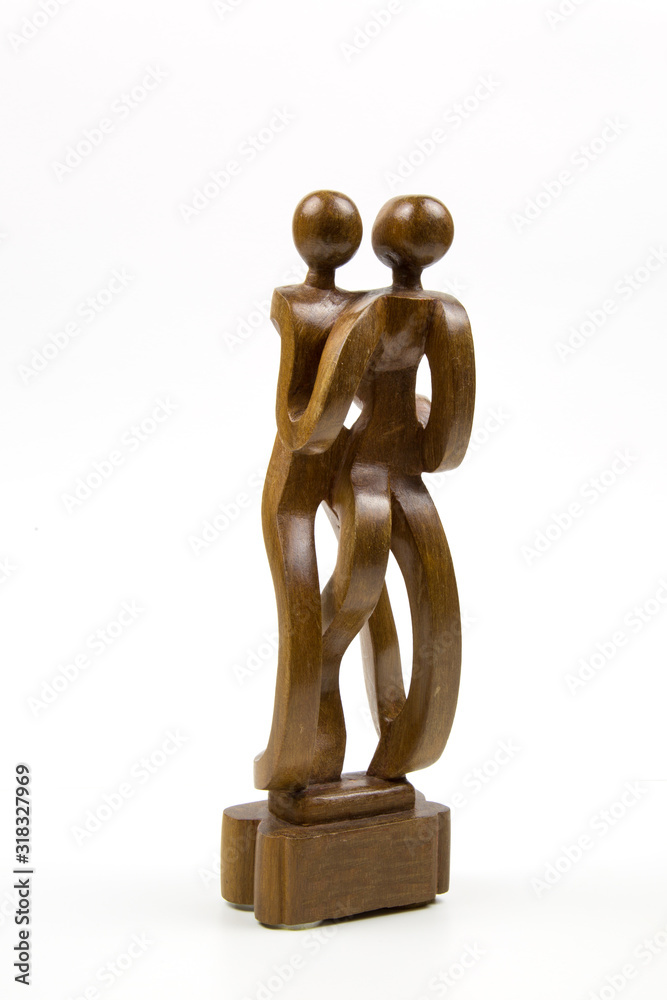Old mahogany statuette intertwined figures of a man and a woman isolated on a white background. Traditional African motifs. Old mahogany statuette intertwined figures of a man and a woman isolated on a white background. Traditional African motifs.