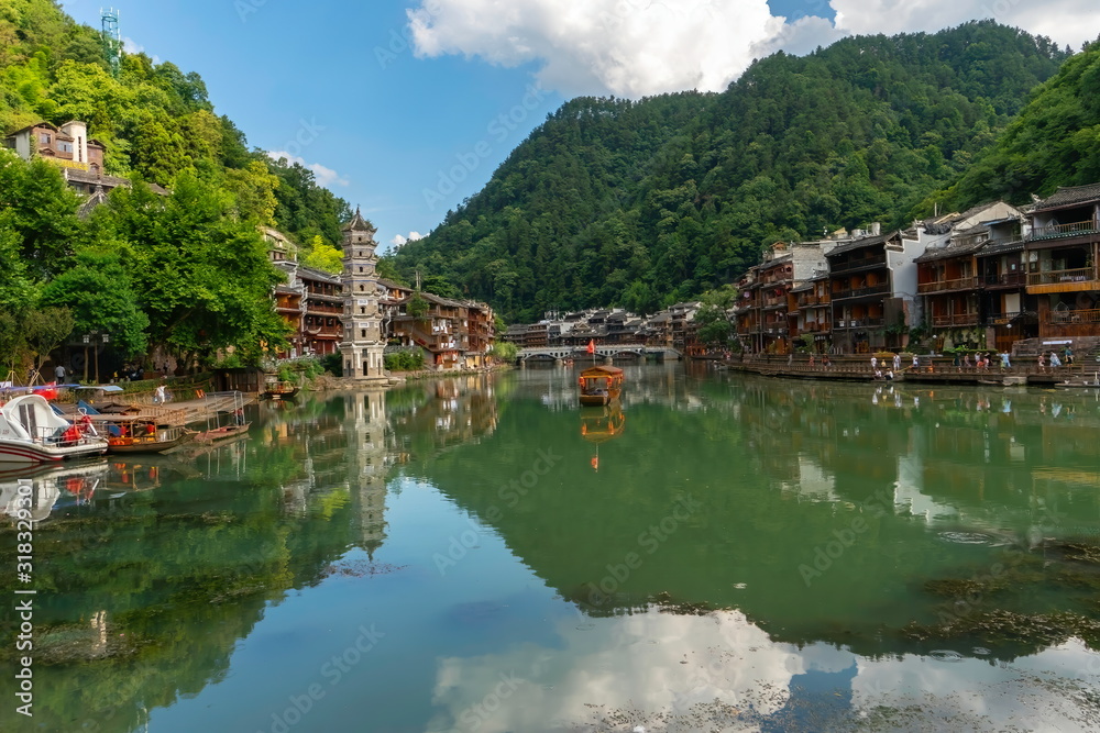 Panoramic view of the old town with the Wanmingta Pagoda and the bridge in the background. Green water reflects the landscape in Fenghuang Ancient Town, Hunan province, China